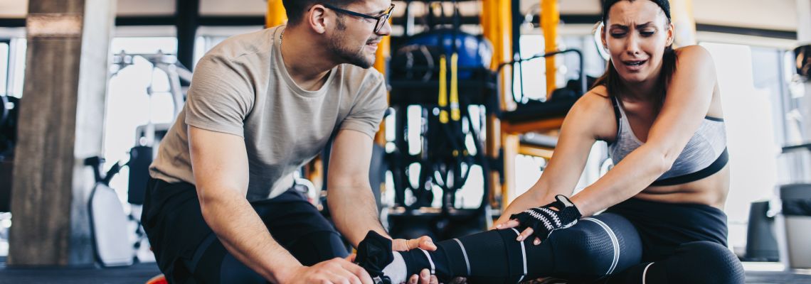 Man helping injured women in gym