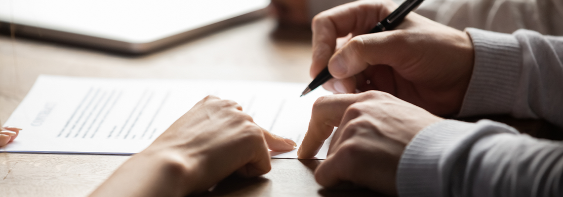 Solicitor pointing at contract showing client where to write signature