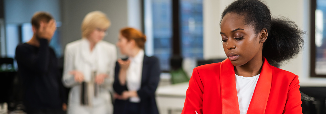 Young african woman is upset because of the ridicule of colleagues