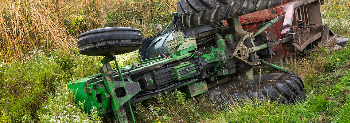 A tractor and cart from a local farm lay in a ditch after rolling off a road