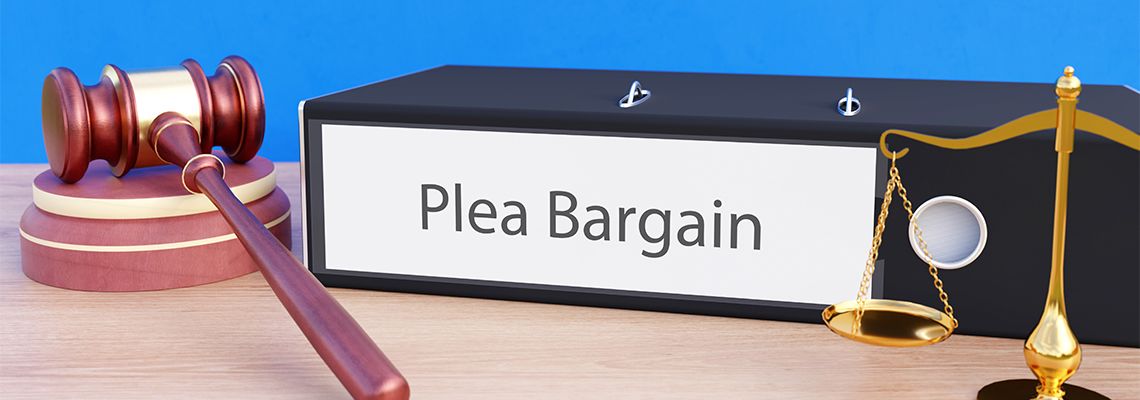 Folder with labeling Plea Bargain, gavel and scale of justice