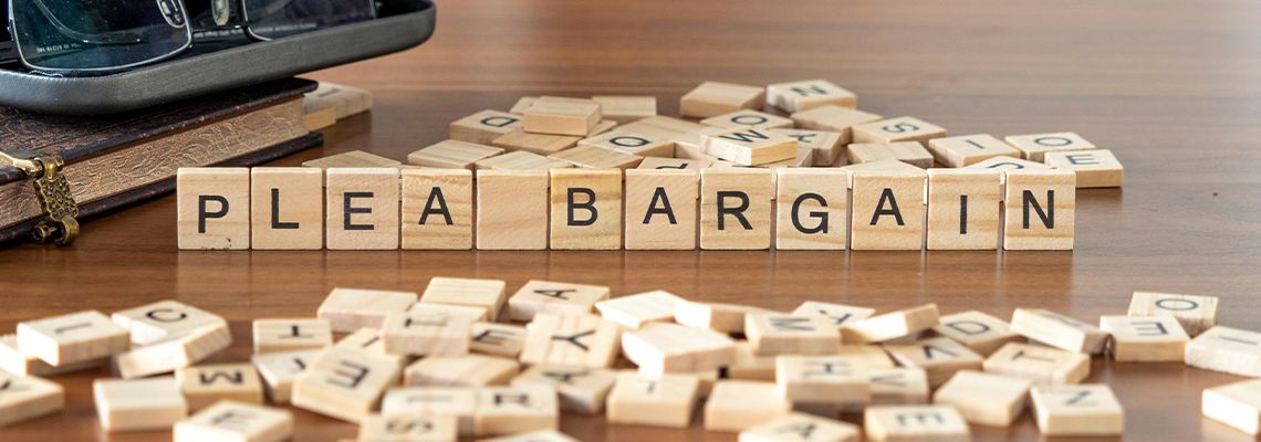Wooden tile with word Plea Bargain