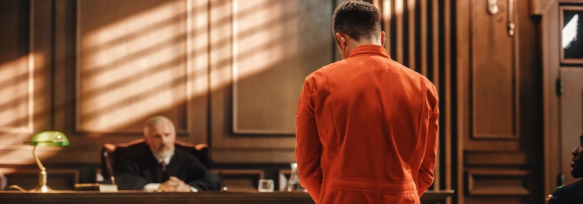 Accused man in yellow Jumpsuit Infront of Judge in courtroom