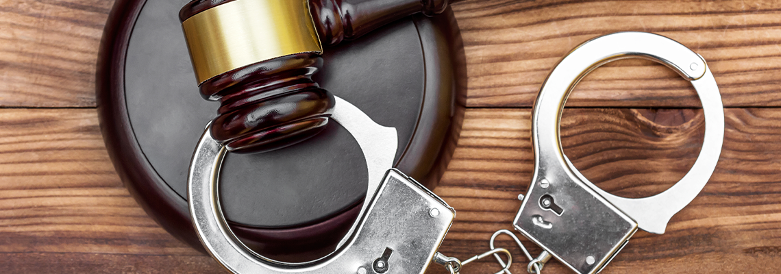 Gavel with stand and handcuffs on the wooden background