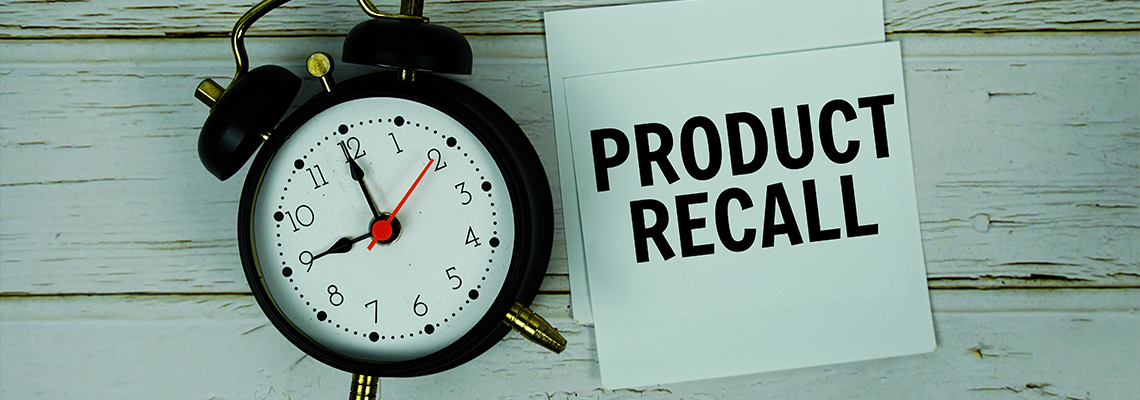 Product Recall text with alarm clock on wooden background