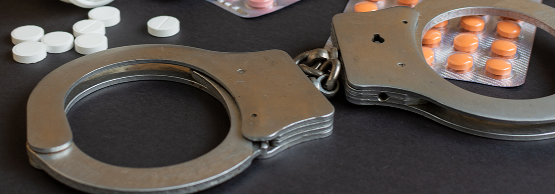 Drugs and handcuffs on table