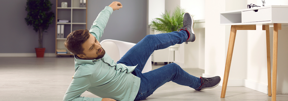 Young clumsy brunette man with unshaven bristles falling down
