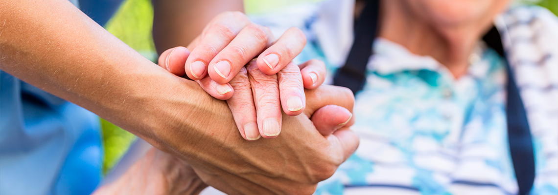 Nurse consoling senior woman holding her hand