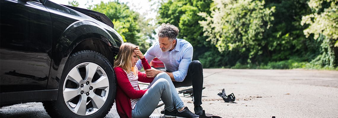 Traumatized women sitting near car after accident