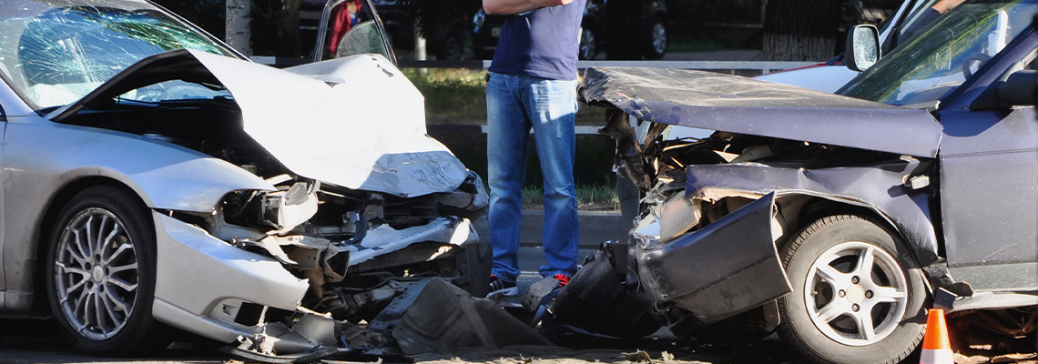 Man Standing between two Crashed Cars