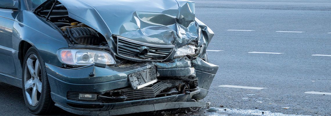 Front of dark color car damaged and broken after accident