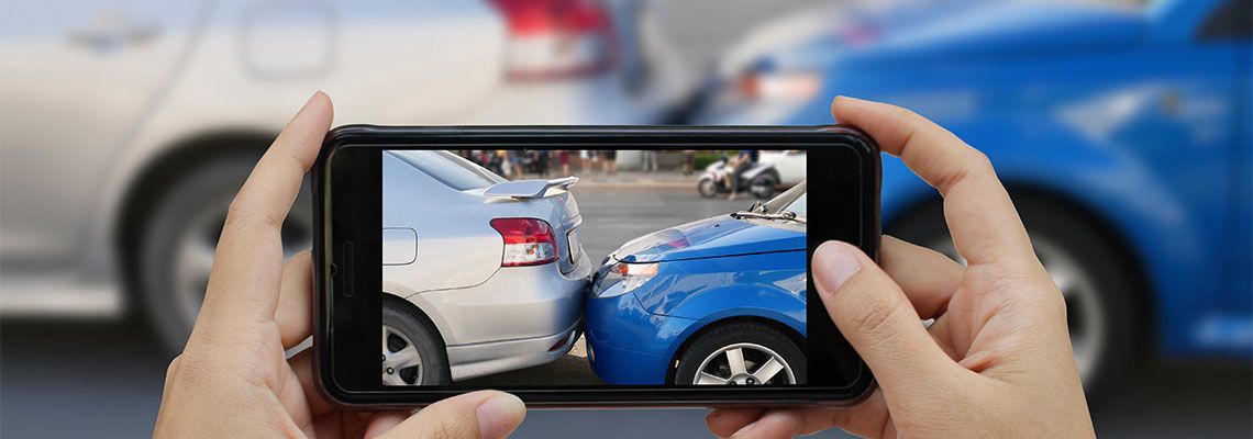 Person taking photo of car accident in mobile phone