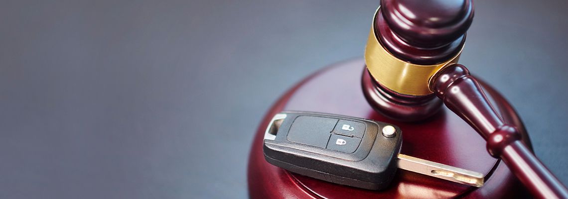 Car key and gavel on table