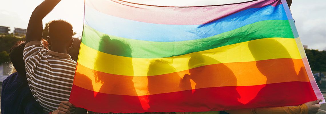 Diverse Group of people holding rainbow flag