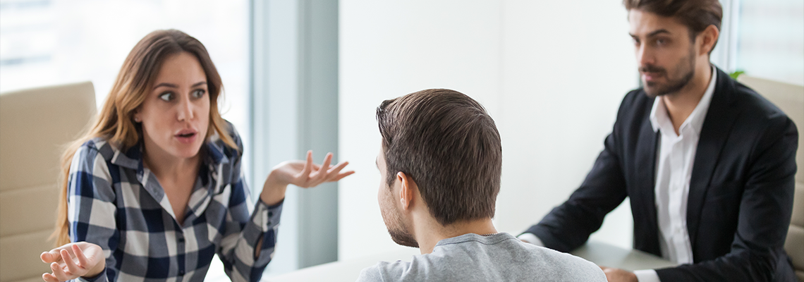 Unhappy depressed young couple at meeting with lawyer about divorce