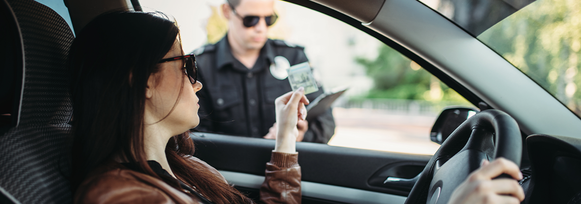 Male cop in uniform writes a fine to female driver