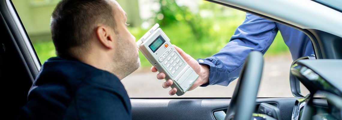 Man blowing into breathalyzer for DUI test