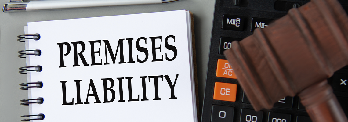 PREMISES LIABILITY - words in notebook with a calculator and a judge's gavel