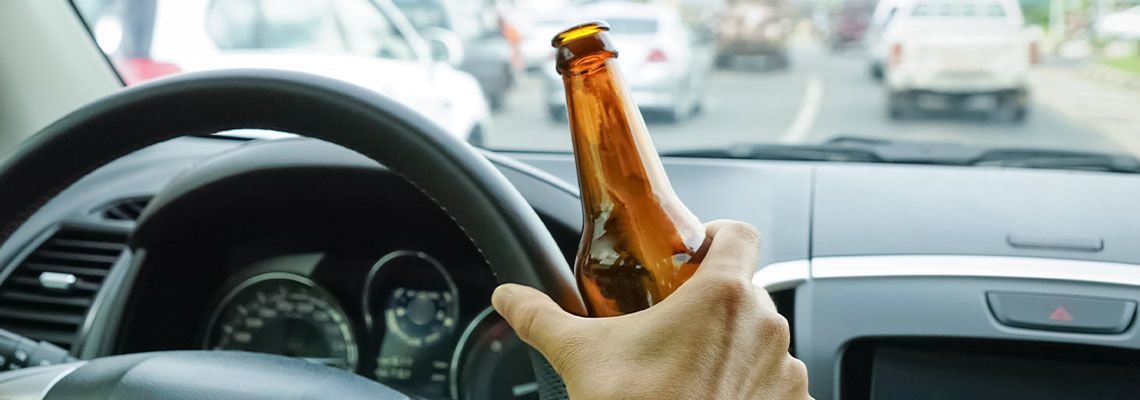 Driver Holding beer bottle in hand while driving