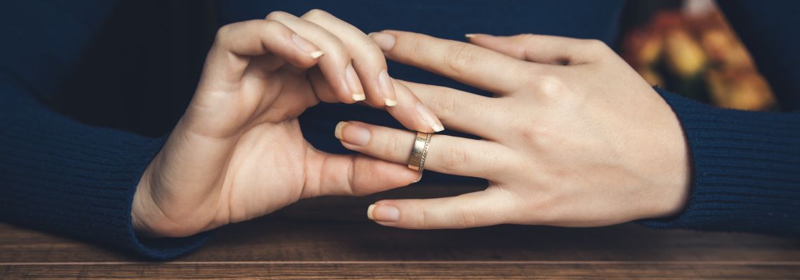 Women removing wedding ring from hand