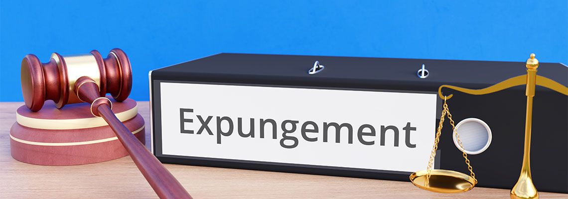 Expungement file folder with gavel and scale of justice at table