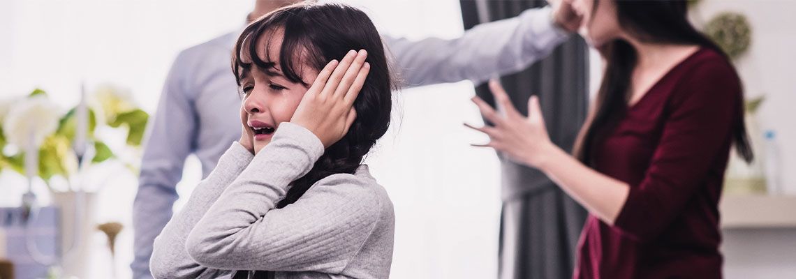 Crying child and fighting parents in background