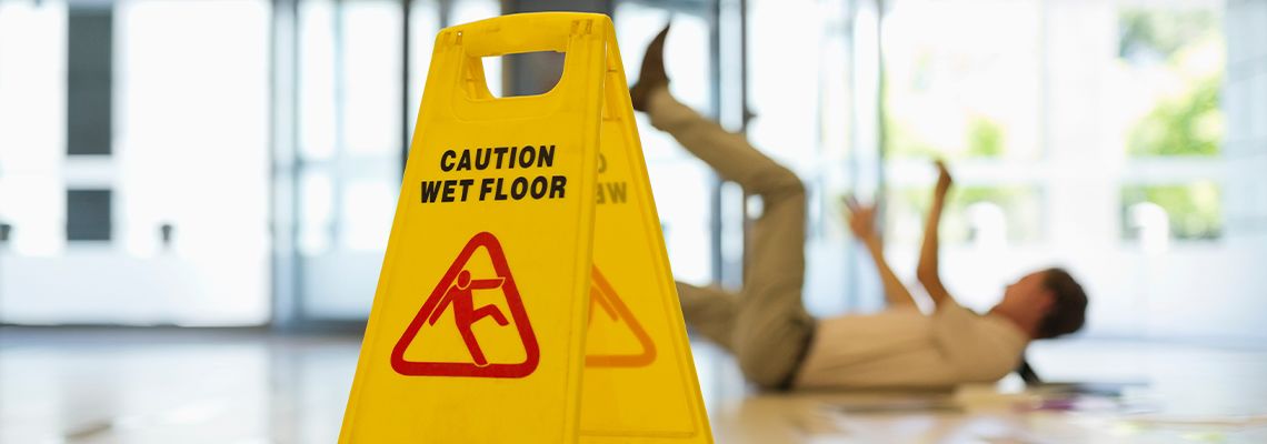 Wet floor caution and man falling on ground on background