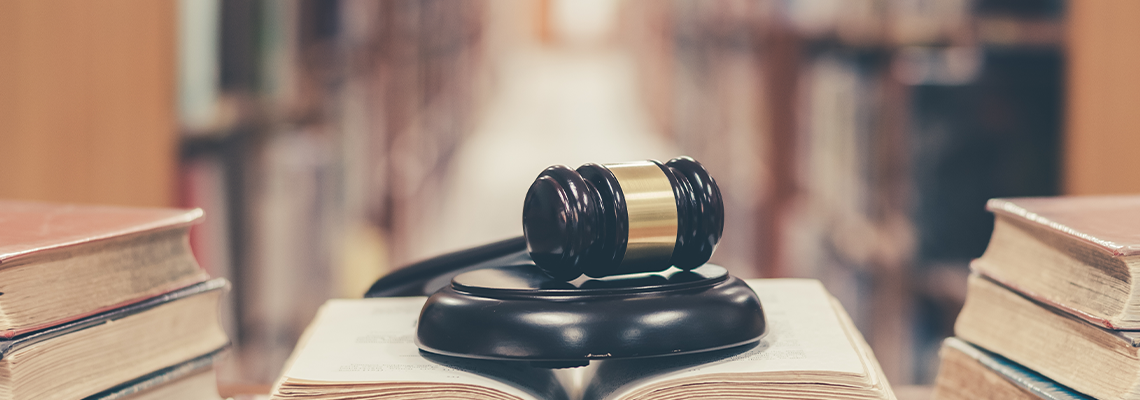 Old book in library with judge gavel on open law textbook