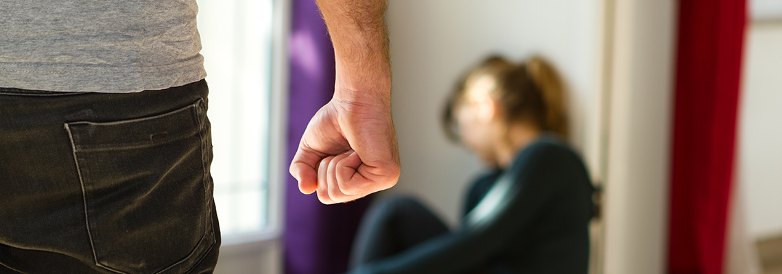 Person making a fist and another person crouched looking away