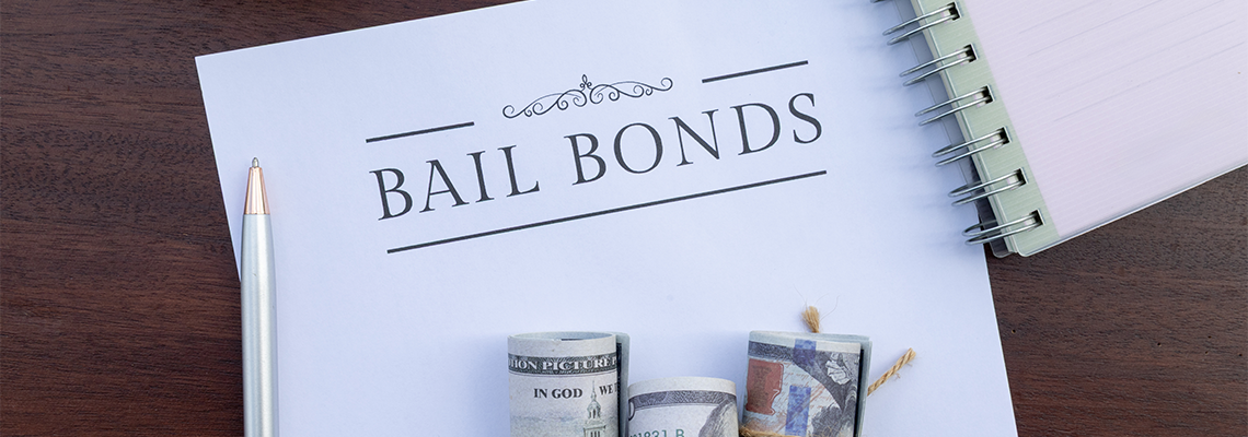 A formal bail bonds document lies on the desk beside a stack of cash