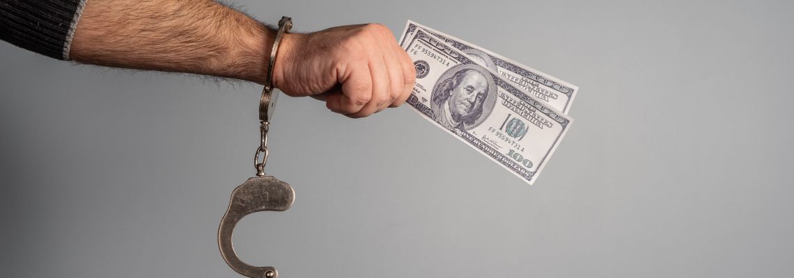 Man in handcuff holding bail money in hand