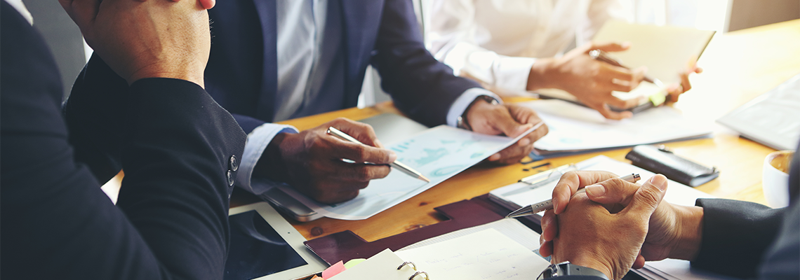 A group of business people are meeting to analyze data for marketing plan