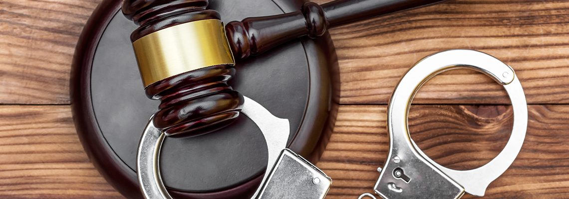 Gavel with stand and handcuffs on the wooden background