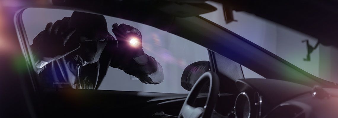 Thief trying to break into parked car