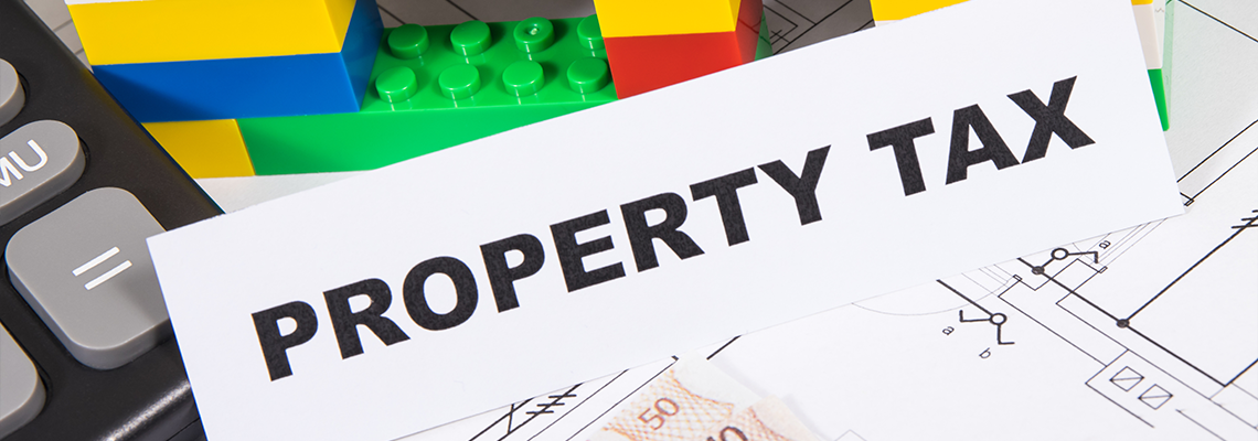 Inscription property tax, euro banknotes, calculator, house made of toy