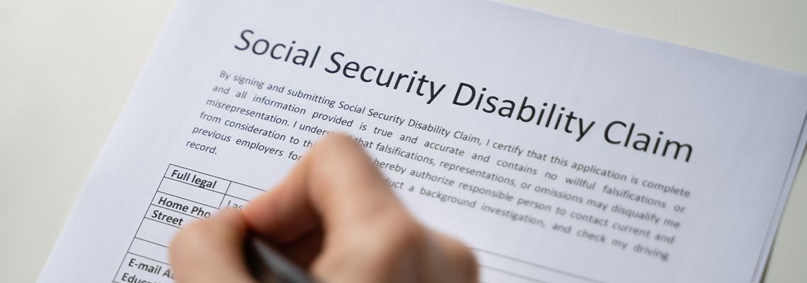 Close-up Of Person Hand Filling Social Security Form