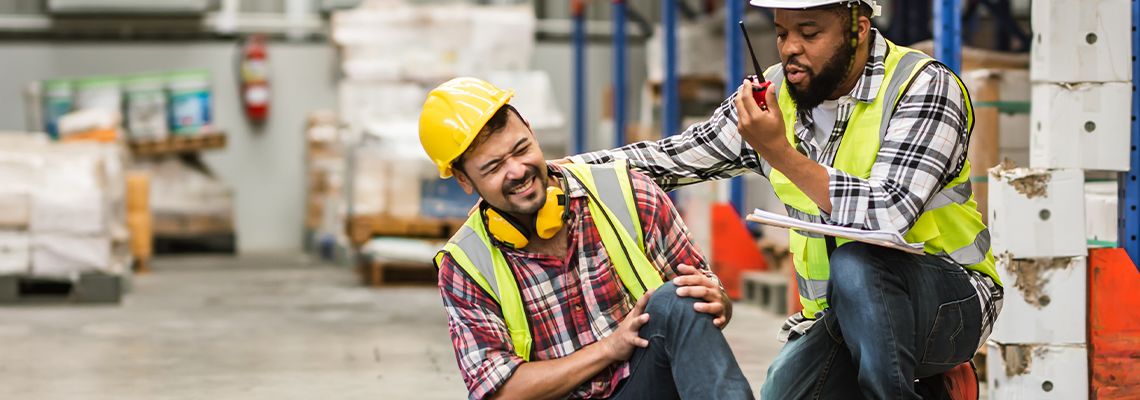 Male worker helping his colleague after accident