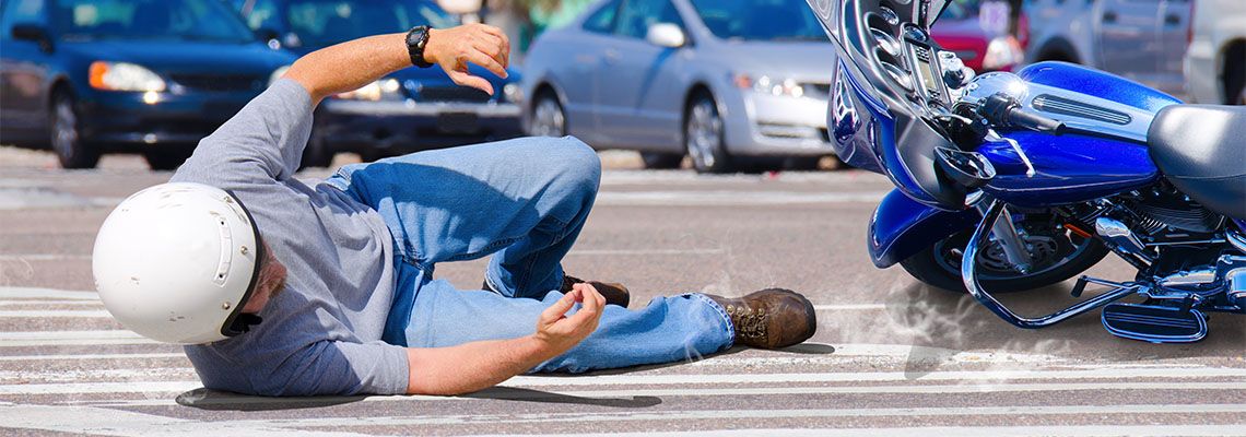 Rider and Motorcycle sliding on road after accident