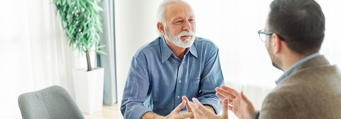 Senior man discusses estate planning option with professional