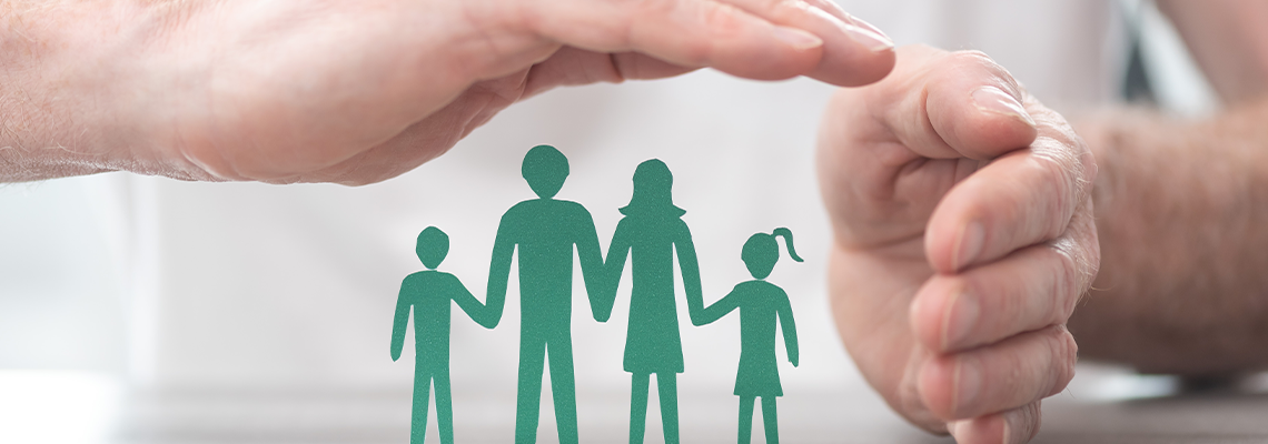 Man's hand protecting family paper model, concept of insurance