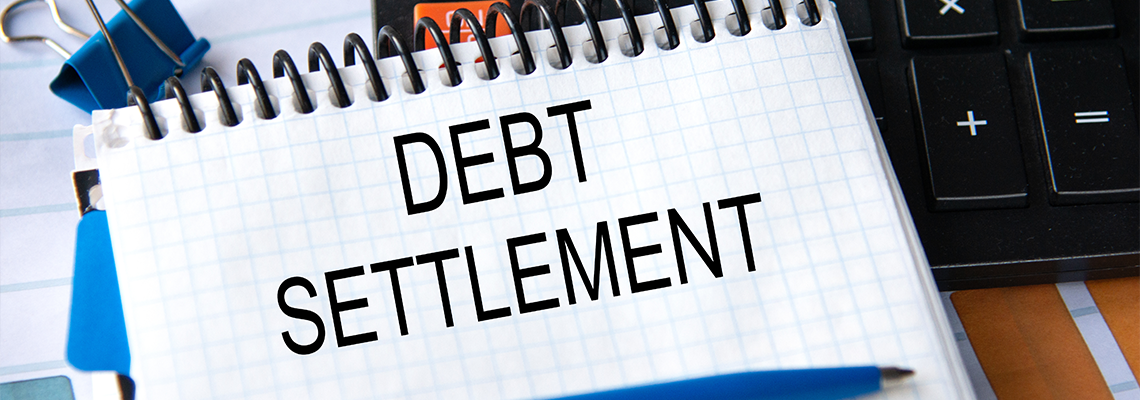 Notebook with the words DEBT SETTLEMENT in the notebook