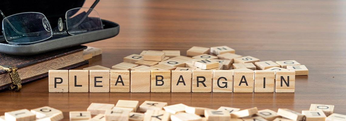Plea Bargain word represented by wooden letter tiles