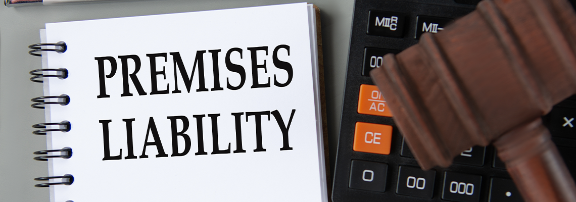 PREMISES LIABILITY - words on notebook with a calculator and a judge's gavel