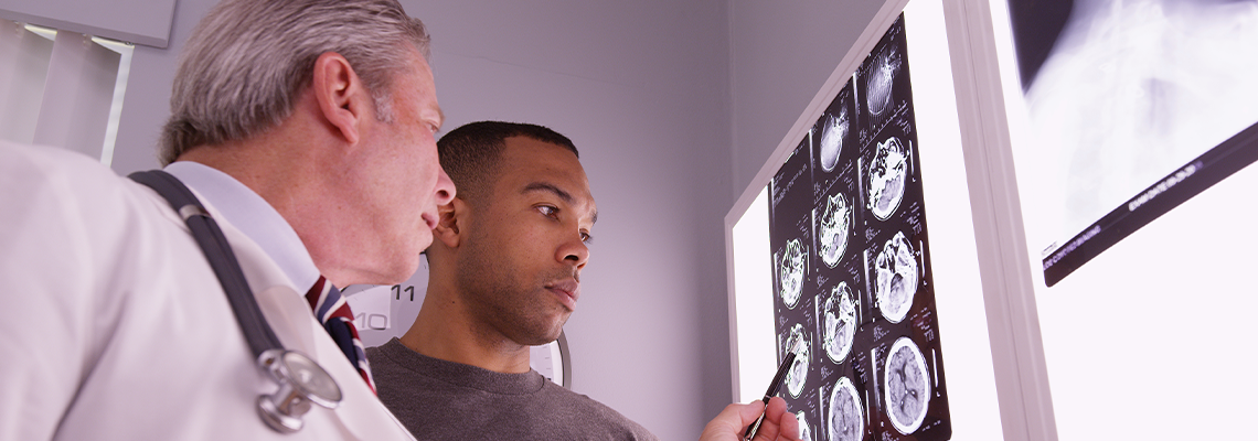 Mid aged medical doctor reviewing x ray of african patient