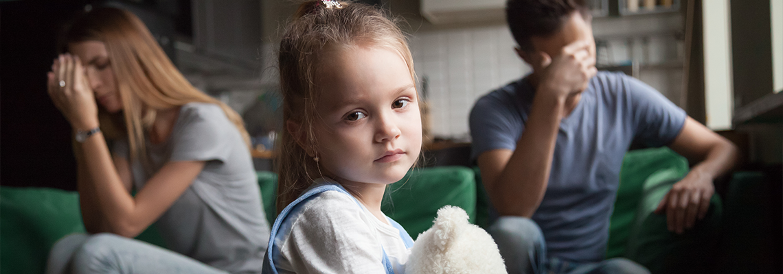 Frustrated little girl upset tired of parents fight looking at camera