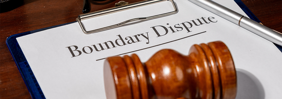 A legal document titled 'Boundary Dispute' rests on a wooden desk