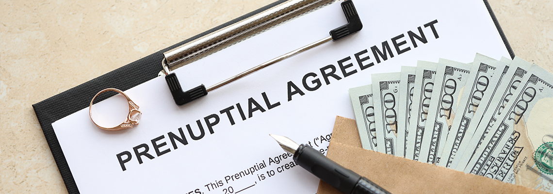 Prenuptial agreement and wedding ring on table