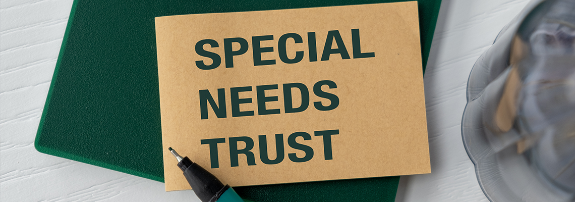 A green notebook with a pen on it and text Special Needs Trust