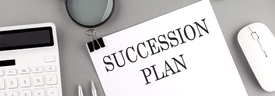 SUCCESSION PLAN written on paper with office tools and keyboard