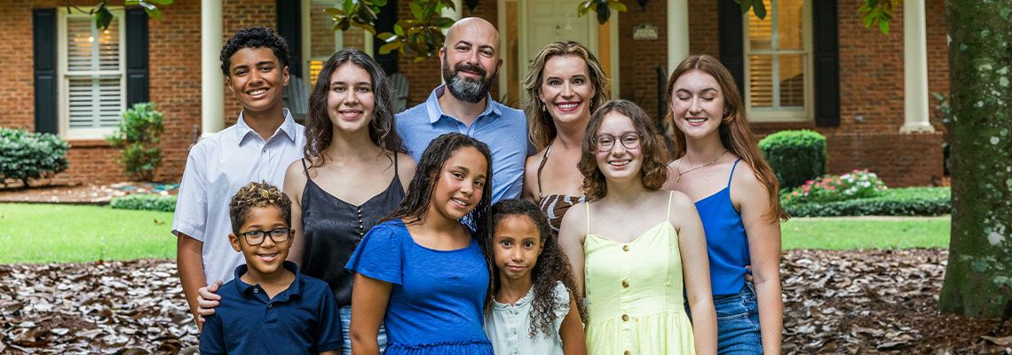 Blended Family standing Infront of their house